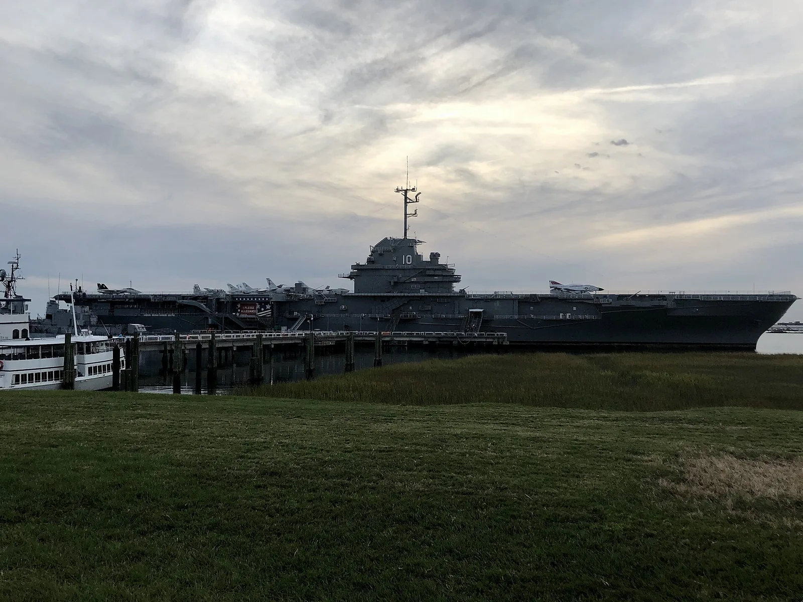 The aircraft carrier USS Yorktown under a gray evening sky at Patriots Point in Mount Pleasant, where Bulldog Tours runs a nighttime ghost tour.