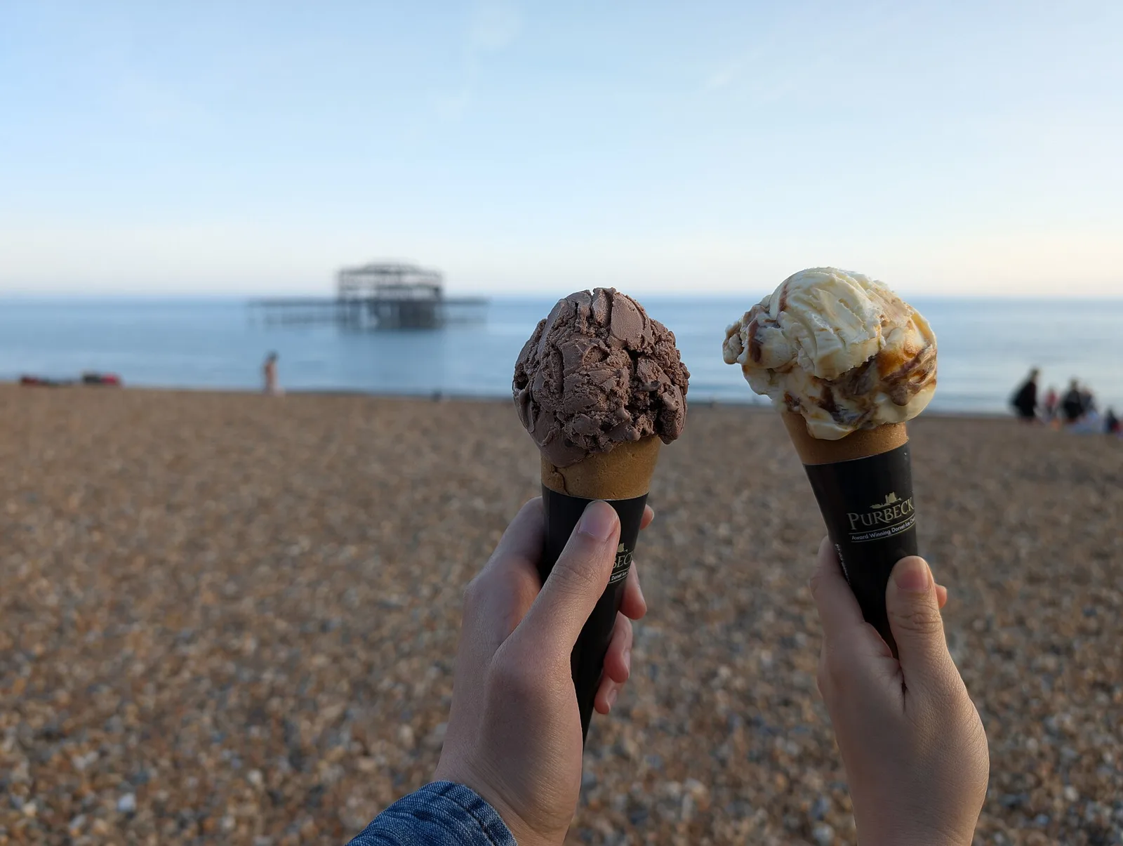 Two ice cream cones held up outdoors. The photo was not taken in Mount Pleasant.