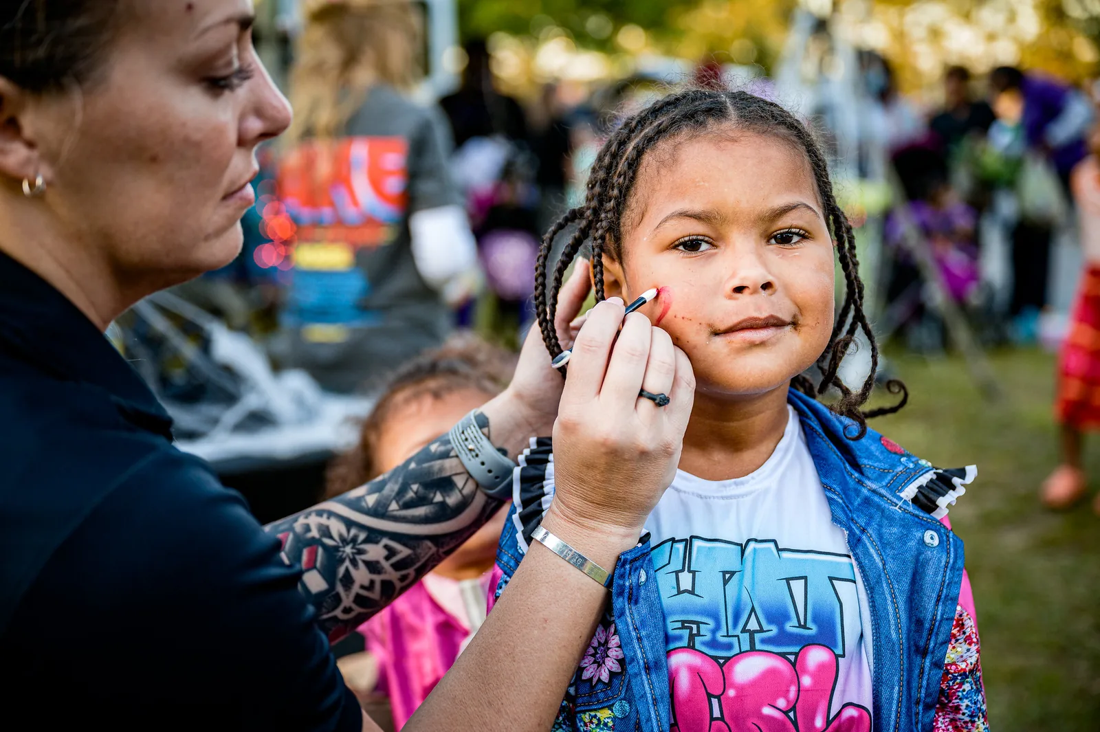 A volunteer paints a child's face at a city trunk-or-treat in Greenville, North Carolina.