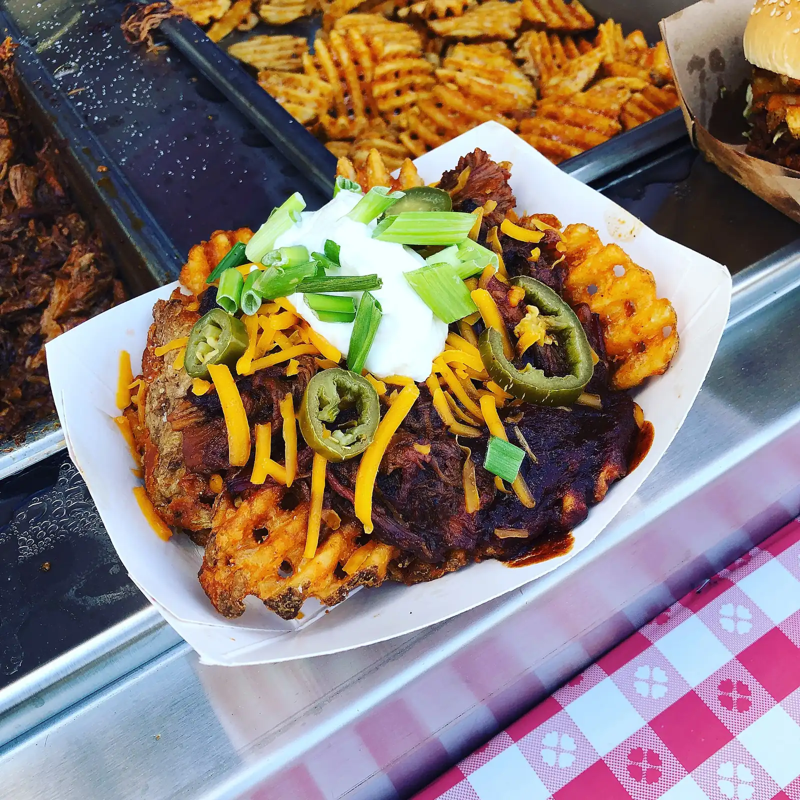 Pulled pork with cheese, jalapenos and sour cream on waffle fries at a barbecue festival. The photo was not taken in Mount Pleasant.